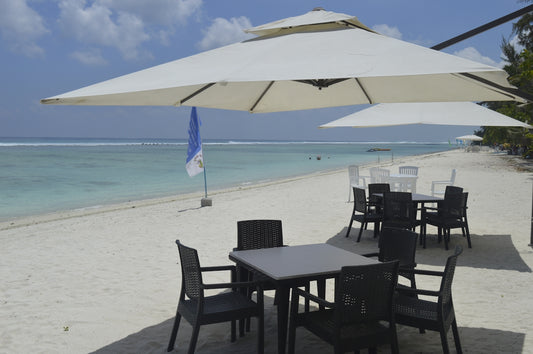 a table and chairs on a beach with an umbrella