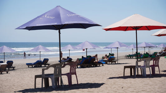 Beach with lounge chairs and umbrellas under clear sky.